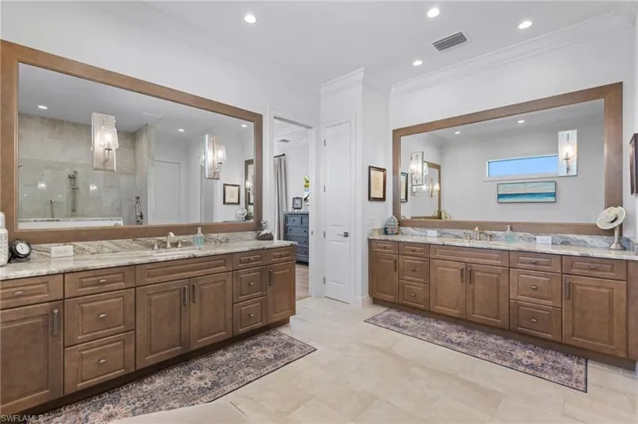 Bathroom with a shower, vanity, and ornamental molding