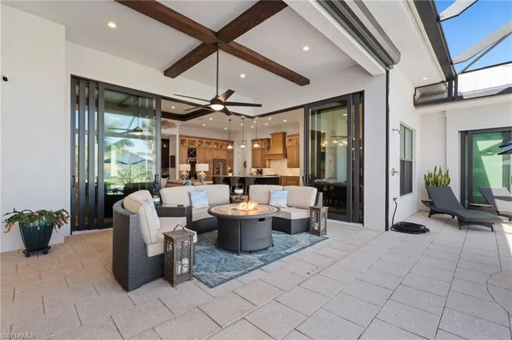 View of patio with an outdoor living space with a fire pit and ceiling fan