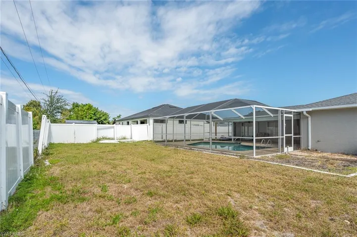 Fenced backyard featuring a sunroom and glass enclosure