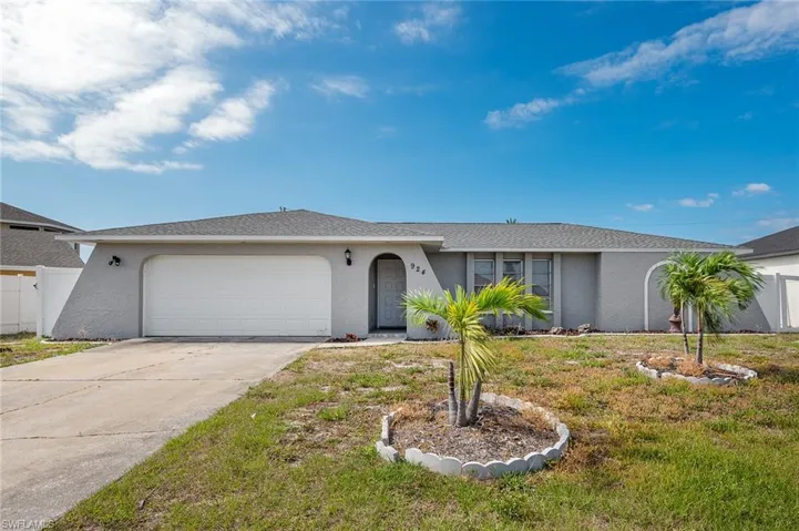 Ranch-style home with a garage, stucco siding, and driveway