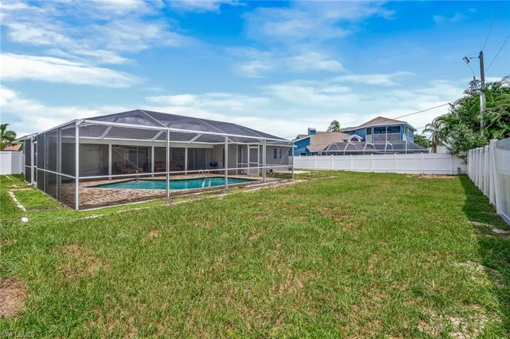 Fenced backyard with a sunroom, a lanai, and a patio area