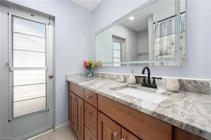 Full bathroom with vanity and light tile patterned floors