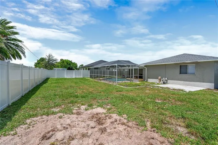 Fenced backyard featuring a sunroom, a patio, and a lanai