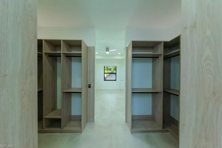 Walk in closet featuring light tile patterned floors and elevator