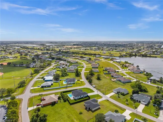 Aerial perspective of suburban area featuring a nearby body of water
