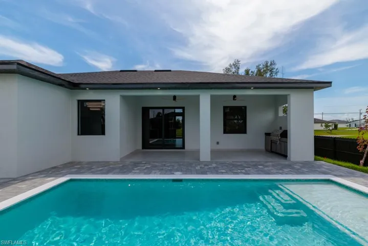 Rear view of house featuring a patio, stucco siding, ceiling fan, exterior kitchen, and a shingled roof