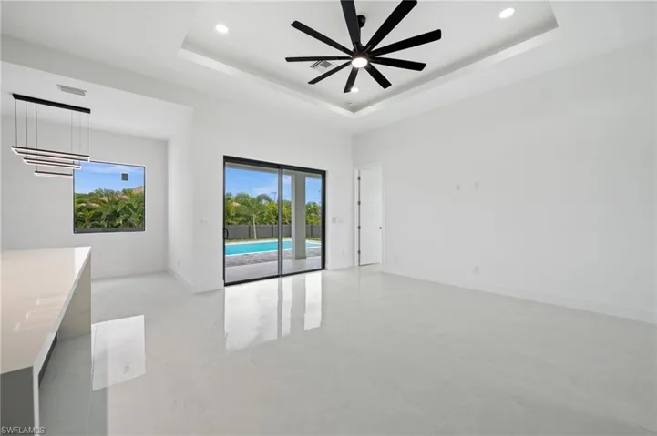 Spare room with a raised ceiling, ceiling fan, recessed lighting, and light tile patterned floors