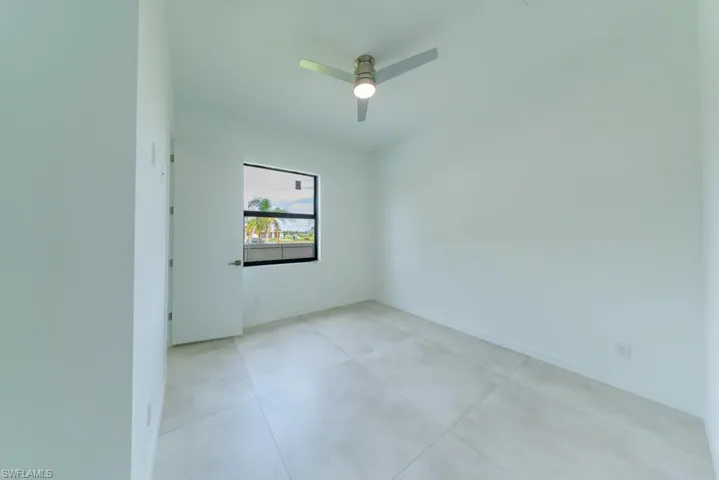 Unfurnished room featuring a ceiling fan and baseboards