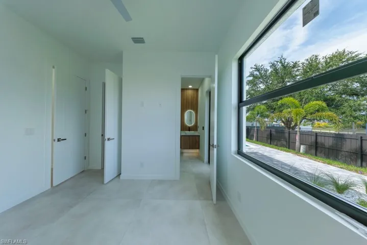 Unfurnished bedroom featuring connected bathroom and a ceiling fan