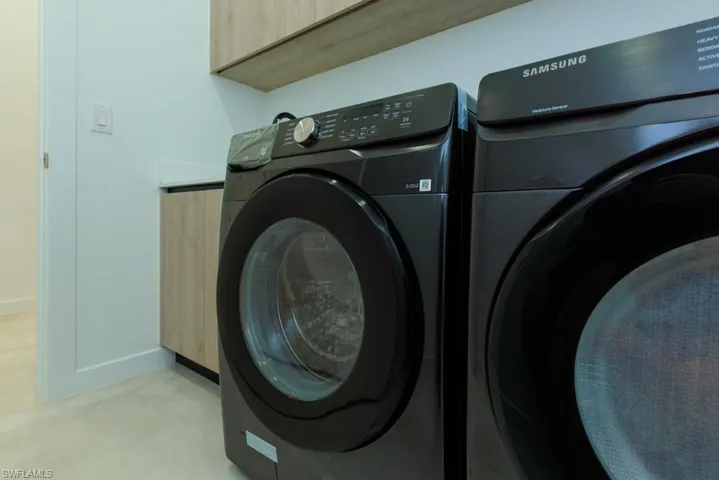 Laundry area with cabinet space and washer and clothes dryer