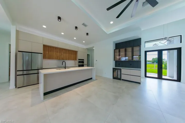 Kitchen with stainless steel appliances, a kitchen island with sink, modern cabinets, open floor plan, and recessed lighting