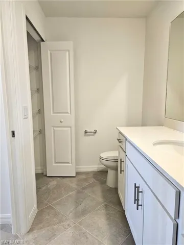 Bathroom with vanity and a closet