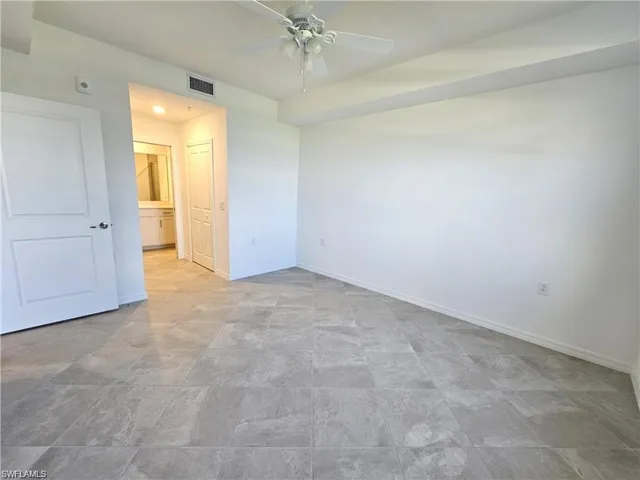 Unfurnished bedroom with ceiling fan and ensuite bath