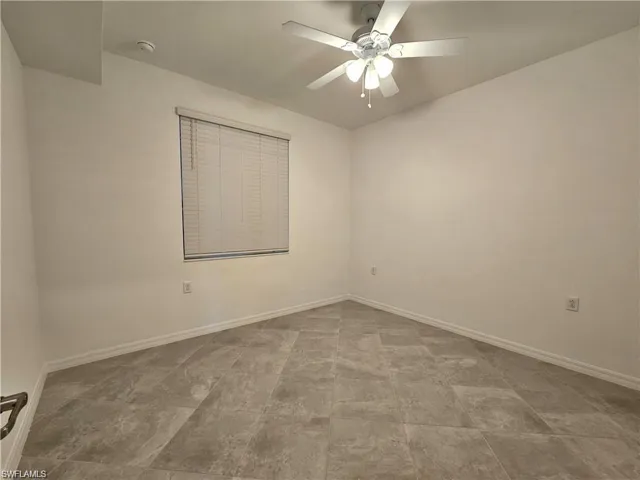 Spare room featuring baseboards and a ceiling fan