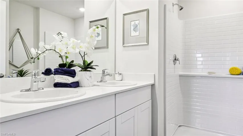 Model home. Bathroom with double vanity and a shower stall