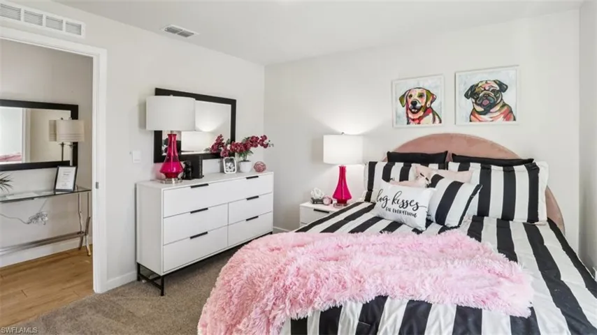 Model home. Bedroom featuring carpet floors and baseboards