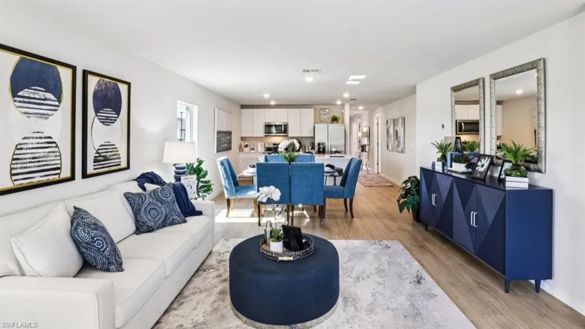 Model home. Living area with light wood finished floors and recessed lighting