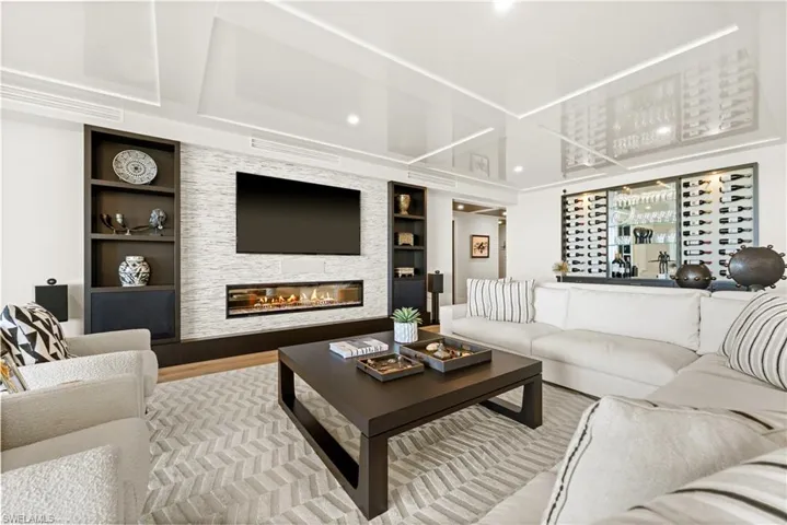 Living room featuring a fireplace, built in shelves, and wood finished floors