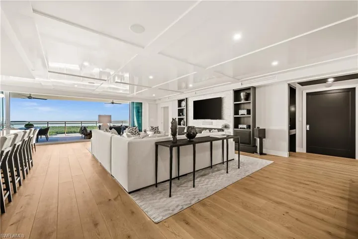 Living room with light wood-style flooring, floor to ceiling windows, and a ceiling fan
