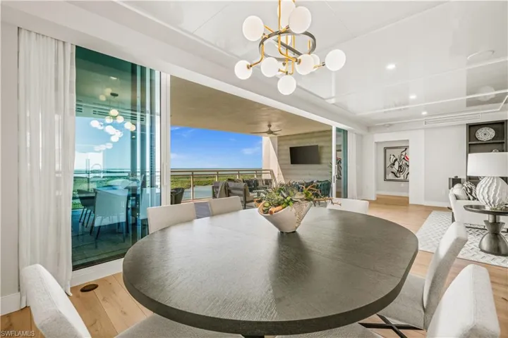 Dining area featuring ceiling fan, a chandelier, and light wood-style flooring