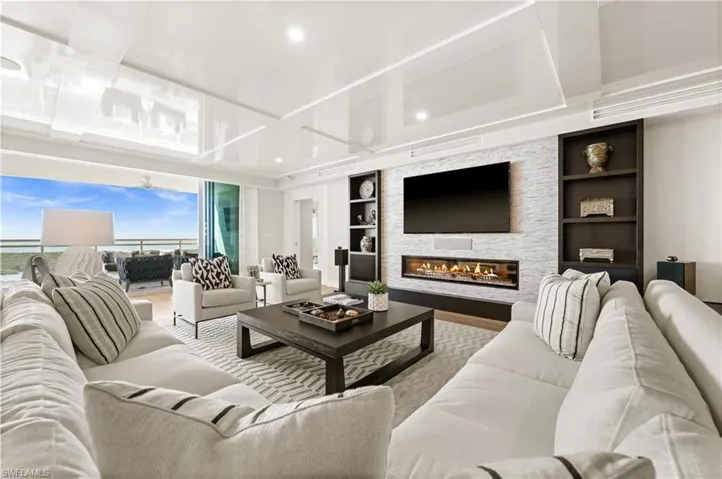 Living area featuring built in shelves, wood finished floors, a fireplace, and recessed lighting