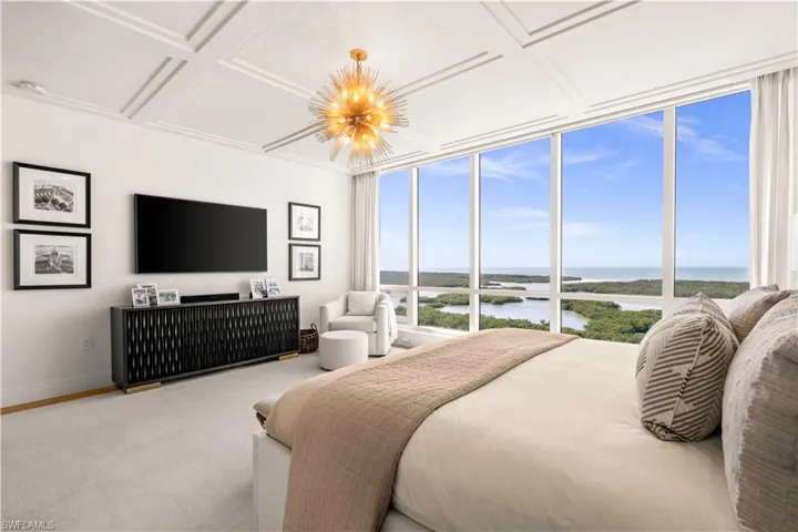 Carpeted bedroom with coffered ceiling and a chandelier