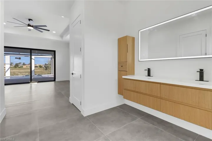 Bathroom featuring vanity, tile patterned floors, and ceiling fan