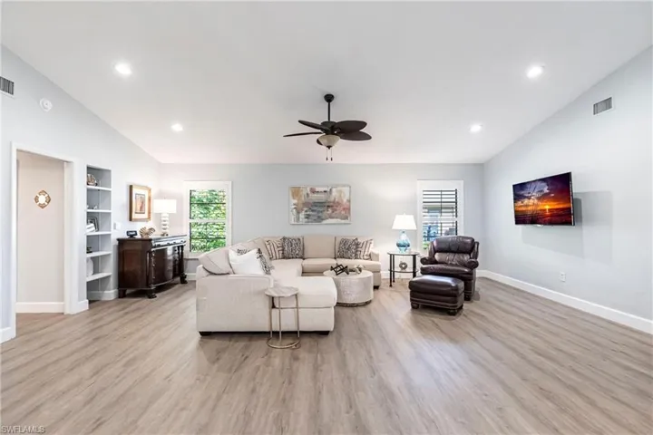 Living area with ceiling fan, baseboards, light wood finished floors, and visible vents