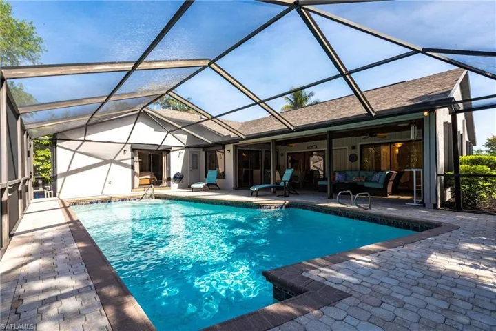 Outdoor pool with a lanai, outdoor lounge area, and a patio area