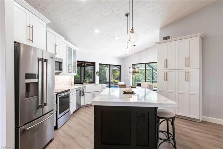 Kitchen with white cabinetry, appliances with stainless steel finishes, and a kitchen island