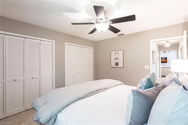 Bedroom featuring visible vents, multiple closets, and ceiling fan