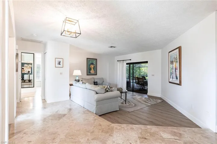Living area with a textured ceiling, baseboards, and visible vents