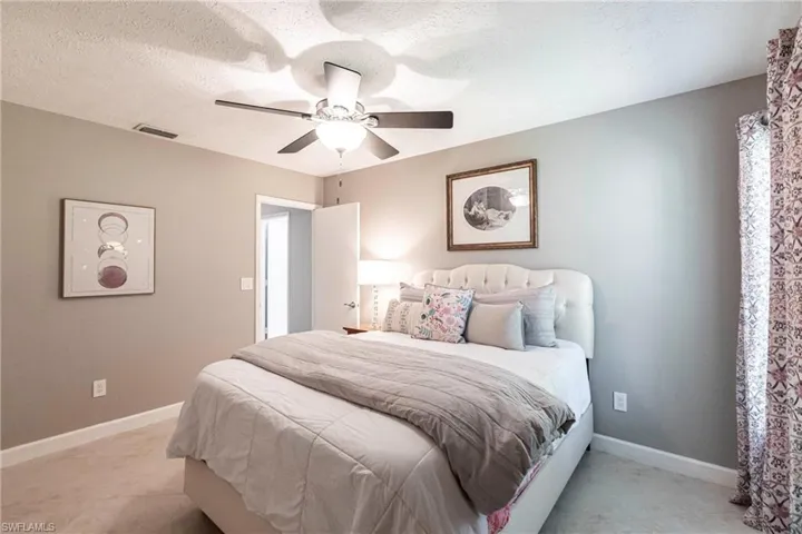 Bedroom featuring baseboards, a textured ceiling, and visible vents