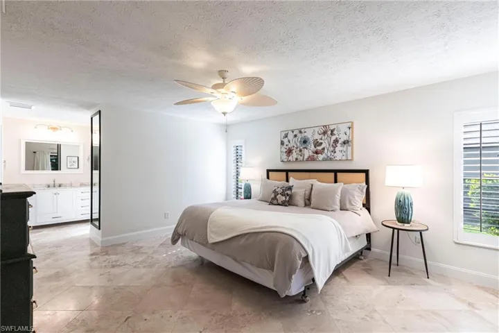 Bedroom featuring baseboards, sliding door out to lanai and ceiling fan