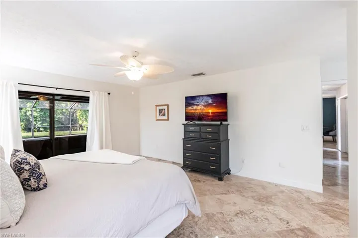Bedroom featuring baseboards, ceiling fan, visible vents, and access to outside