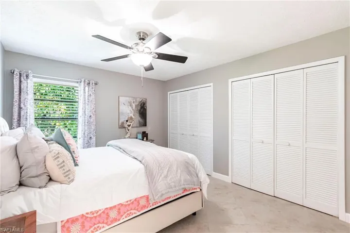 Bedroom featuring baseboards, multiple closets, and a ceiling fan