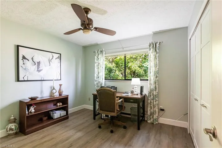 Office area featuring baseboards, a textured ceiling, wood finished floors, and ceiling fan