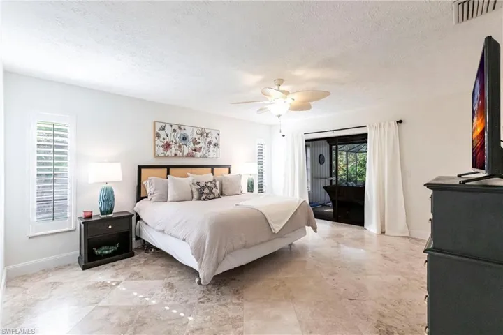 Bedroom featuring tile flooring, a ceiling fan, and access to lanai
