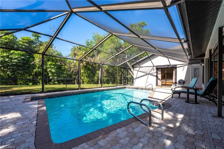 Pool with glass enclosure and a patio area