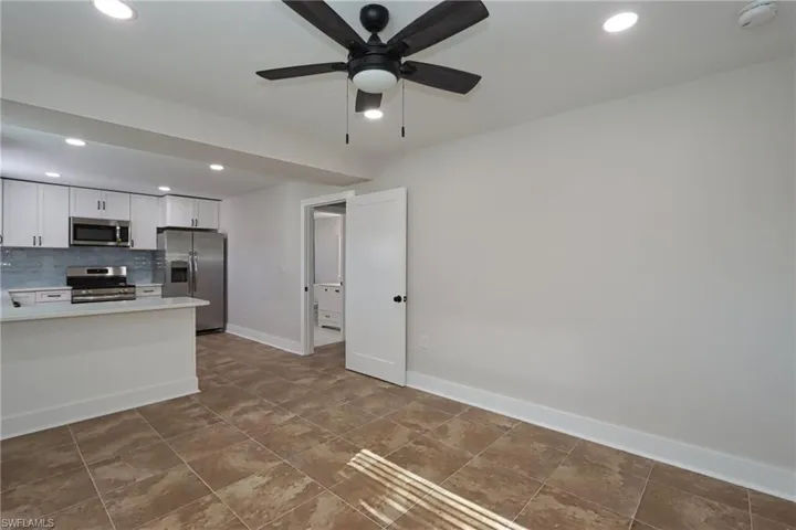 Kitchen featuring recessed lighting, stainless steel appliances, white cabinetry, ceiling fan, and tasteful backsplash