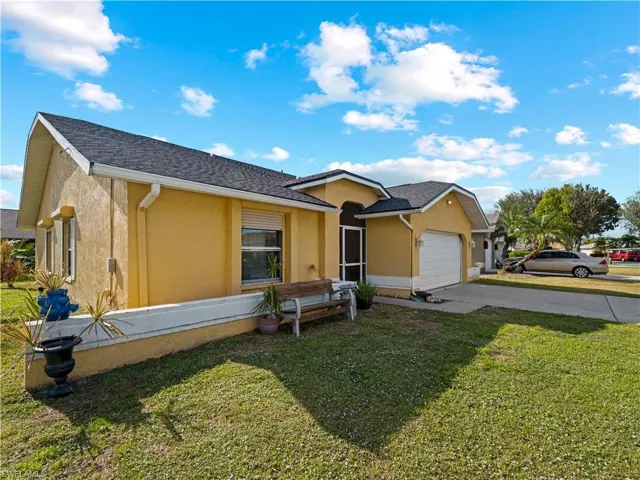 View of front facade featuring a front yard and a garage