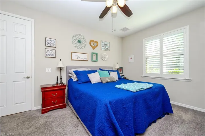 Carpeted bedroom featuring ceiling fan and baseboards