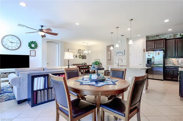 Dining space with a chandelier, light tile patterned floors, recessed lighting, and ceiling fan