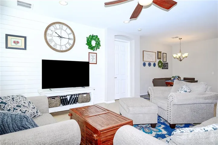 Living area with tile patterned flooring, recessed lighting, a ceiling fan, and a chandelier