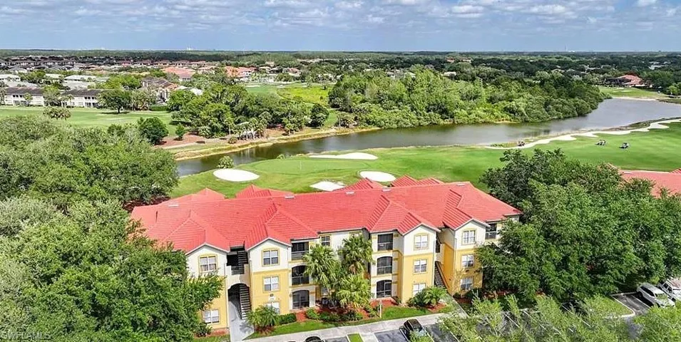 Birds eye view of property with golf course view and a water view