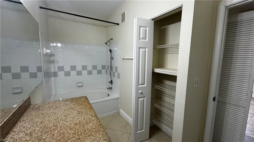 Full bath featuring baseboards, visible vents, tile patterned flooring, and  shower combination