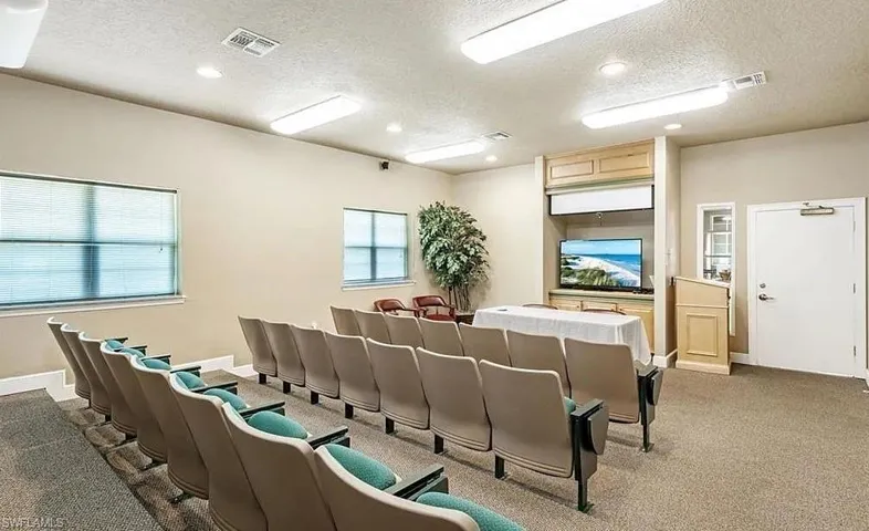 Carpeted home theater with visible vents, a textured ceiling, and recessed lighting