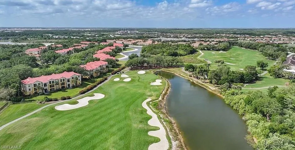 Drone / aerial view with golf course view and a water view