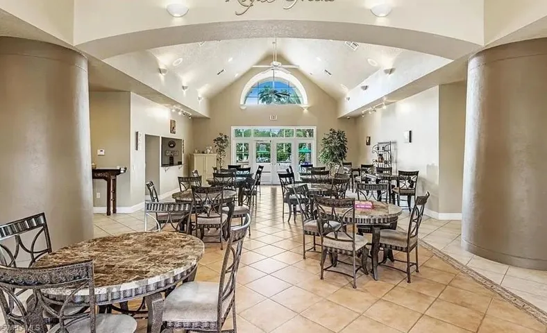 Dining area with light tile patterned floors, a ceiling fan, high vaulted ceiling, and baseboards