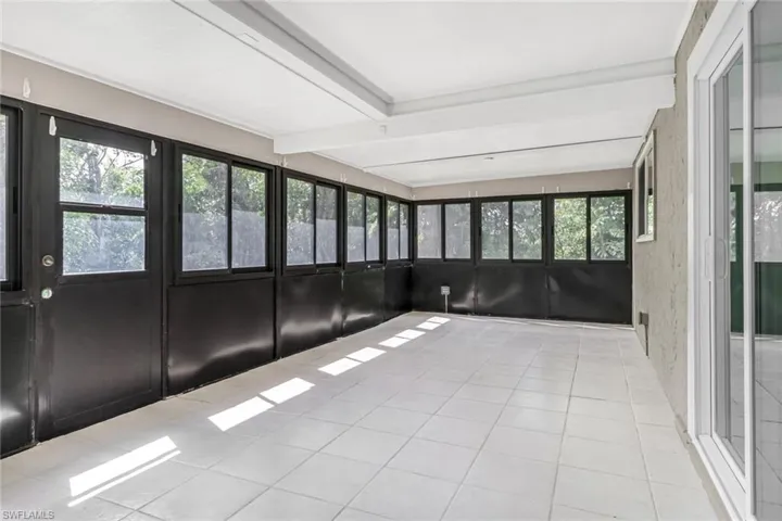Unfurnished sunroom with beam ceiling and a healthy amount of sunlight
